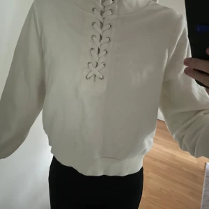 Vit tröja - Snygg vit tröja från Kappahl. Går upp lite i halsen och har snören.