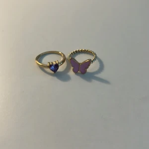 Ringar - Två st ringar, en med lila hjärta och en med rosa fjäril