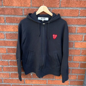 COMME des GARCONS hoodie - Snygg o simpel designer hoodie med zip från COMME des GARCONS i svart. Använd, men i bästa skicka utan några som helst tecken på användning! Nypris runt 3000kr