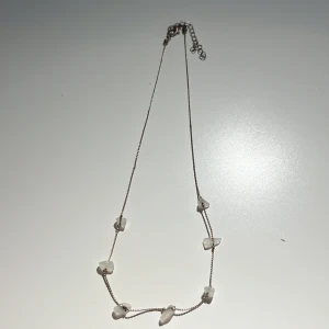 Halsband med vita stenar  - Säljer ett halsband med vita stenar på. Har blivit lite lite missfärgat eftersom jag inte har använt det så mycket.