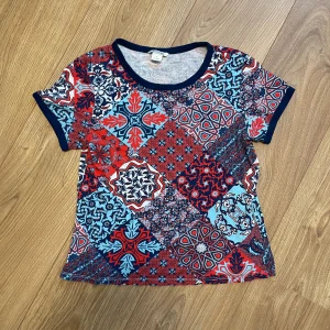 Färgglad topp - Färgglad t-shirt från Monki i storlek S.