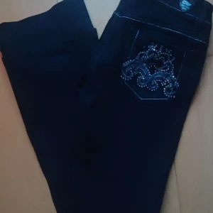 Bootcut jeans med låg midja  - Ett par jätte snygga Y2K jeans med rhinestones på bakfickorna. De är boot cut och låg midjade. 😻😻 Jag säljer dom då de tyvärr inte är min stil längre☺️ Skriv till mig om du vill ha måtten! 