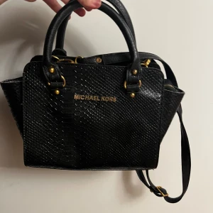 Äkta michael kors väska  - äkta michael kors väska i snake design. utan kvitto eller påse för den är gammal men är i vackert skick, Dragkedjan är lite sönder på slutet och lite svår att öppna o stänga, men annars bra, kan ha som handväska också, för mer info gärna kontakta mig