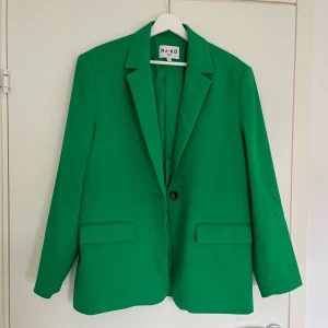 NA-KD, Grön Kavaj - Riktigt snygg, något oversize kavaj från NA-KD i storlek 36.  Har axelvaddar som ger en snygg passform.   Väldigt fint skick, inga tecken på användning! Nypris: 699kr.
