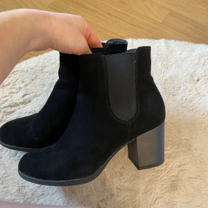 Klackskor  - Svarta klackskor från Din sko i mockaimitation. Använda några få gånger och har några små ”repor” längst fram men syns inte tydligt i verkligheten. Klacken är 7cm. Ser smutsiga ut i kameran men det är damm som går att putsa bort. 