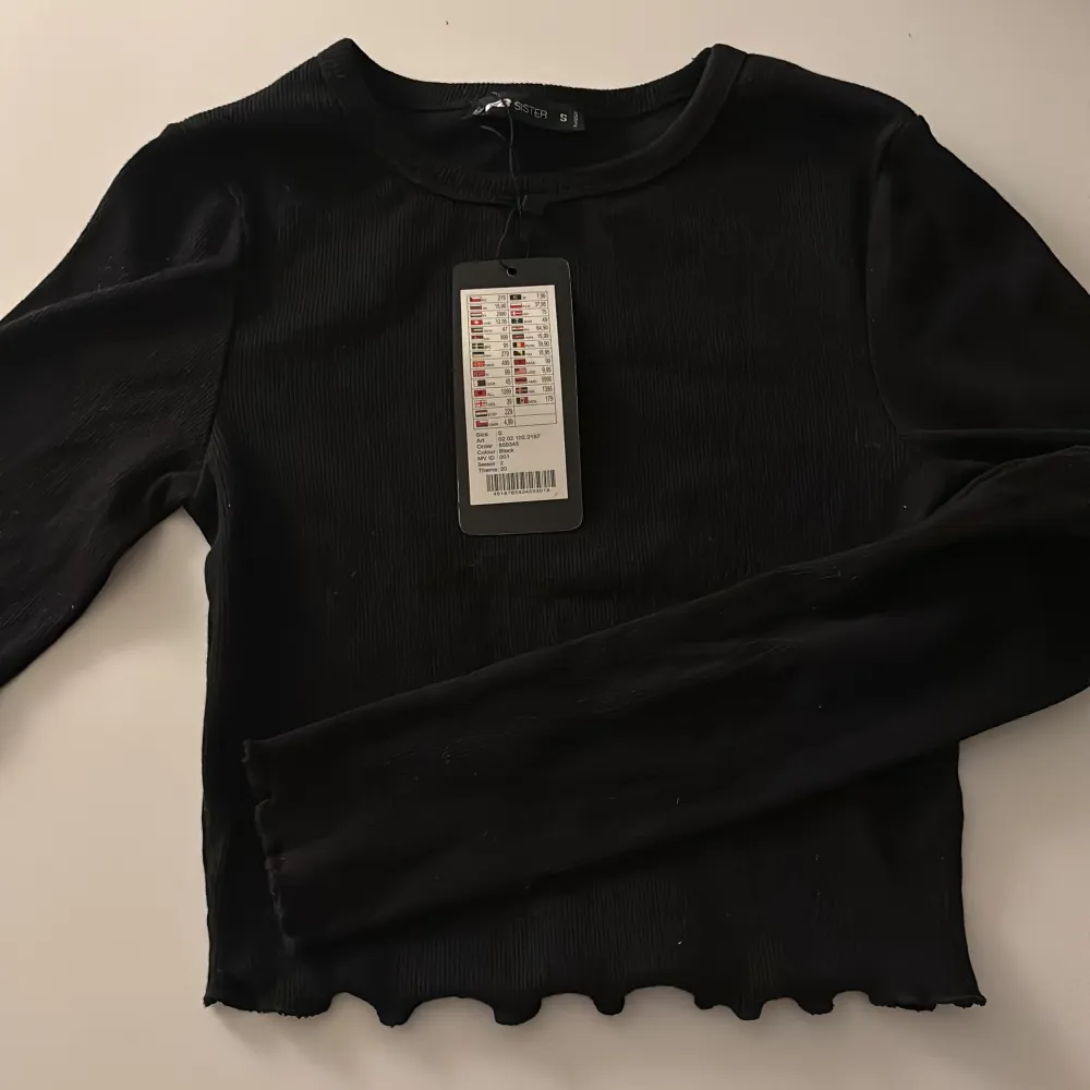 Säljer en svart ribbad crop top med ”volanger” i storlek S. Köpt för 95kr, säljer för 30. Köparn betalar frakten, kan även mötas i Hällefors/Örebro. . Toppar.