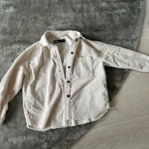 Vårjacka  - Tunn vårjacka i ribbat bomull material. Jackan är skjortliknande och medellång. Perfekt till våren och tidig höst. 