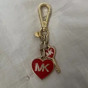 En nyckelring från MK i guld med röda synliga detaljer. Använd sparsamt och i ett väldigt bra skick, inga defekter.  Köpt i new york. Skriv för fler bilder🩷