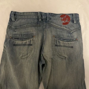 coola jeans  - super coola jeans med coolt tryck på baksidan!! de är ganska stora i midjan men finns inget inte ett skärp kan fixa 😆har köpt dem second hand så dem är rätt slitna och har några hål längs ner på byxan