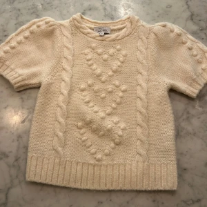 Stickad topp -  Stickad tröja med korta armar.