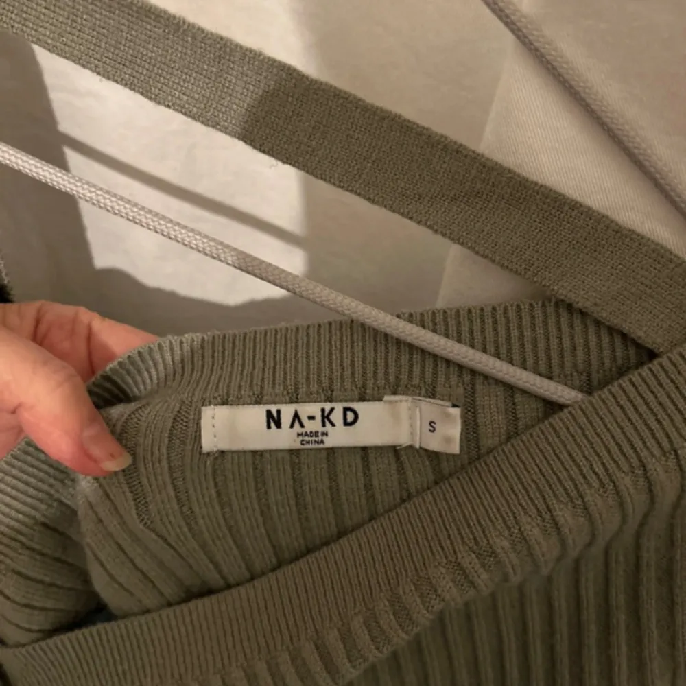 En gullig olivfärgad ribbad tröja med öppenrygg från NA-KD. Använd ett fåtal gånger. Storlek S.. Blusar.