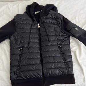 Moncler cardigan kofta - Original storleken är L men den har tagits till en skräddare så storleken nu är S/M den är lite sol bränd på vissa ställen som på luvan och jätte lite på armarna och längst ner på koftan 