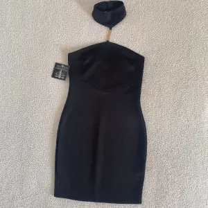 Supersnygg svart miniklänning från Nelly med guldig kedja och choker. Ny med tags kvar. Gratis vid köp av annat över 300kr. 🤗
