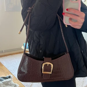 Superfin brun väska  - Så fin brun väska, justerbart band. Köpt second hand men finns inga defekter alls, ser ut som nyskick!