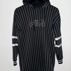 Fila Hoddie klänning - Härlig Hoddie klänning i bomull, skall vara lite oversize, svart mudd nertill. Fint skick Nypris 800;- 