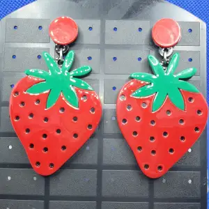 Den här örhänget föreställer jordgubbar / Jordgubbe med måtten är ca7 ×4 cm. Material av metall och akryl. Otroligt snygga örhängen av hög kvalitet.  Grymt snygga örhängen, oanvända, nyskick