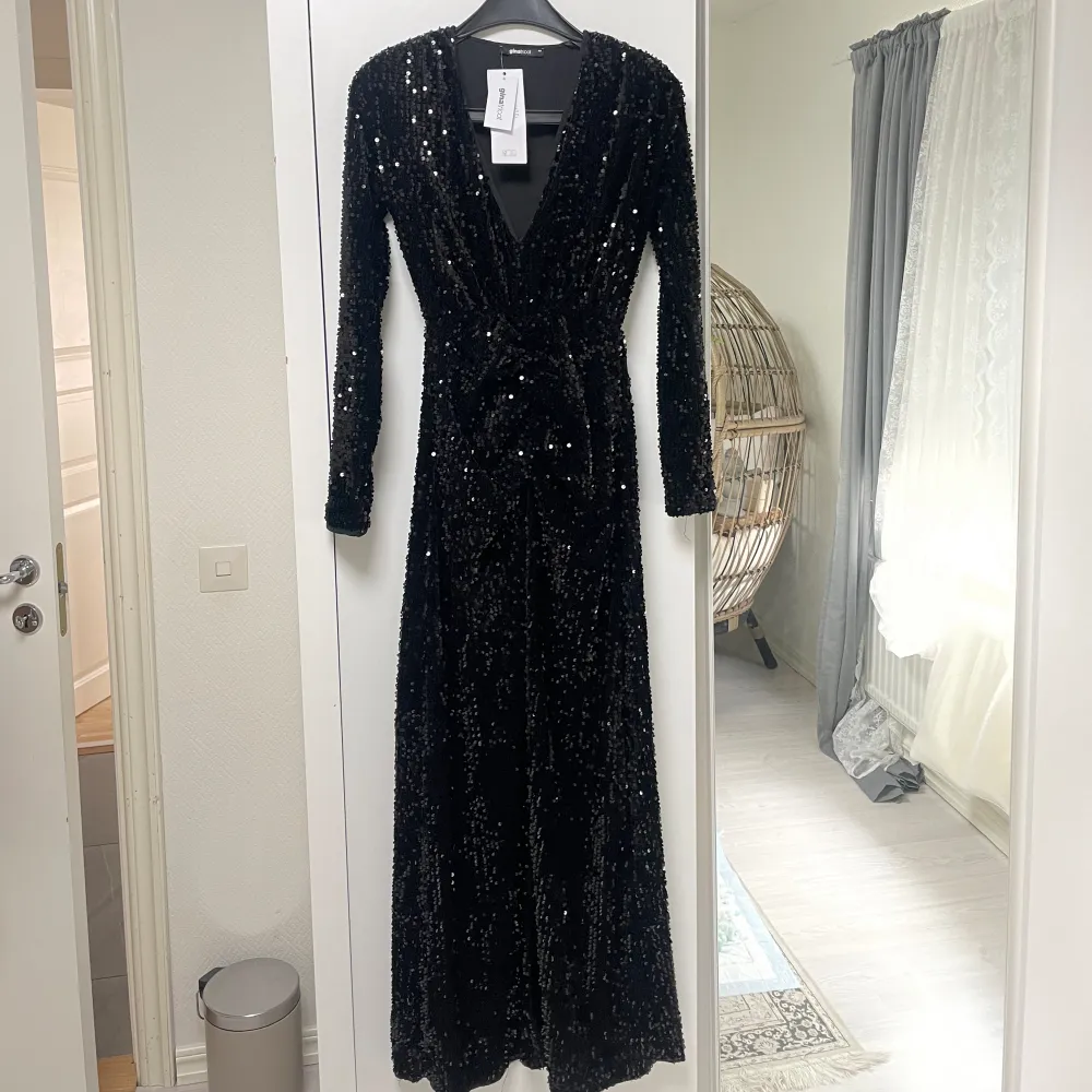 Long-sleeved dress with sequins. The dress is black and has a maxi length. It has a slit at the front and a v neckline. New price: 800kr (79.9 EURO). Klänningar.
