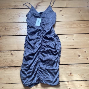 Satin klänning NAKD - Säljer denna Satin klänningen från NAKD i storlek 36. Den är grå och går ungefär till knäna eller lite ovanför. Formar kroppen väldigt fint men är tyvärr för liten på mig nu. Säljer för 400 inklusive fraktkostnad🩵 Nypris är runt 700!