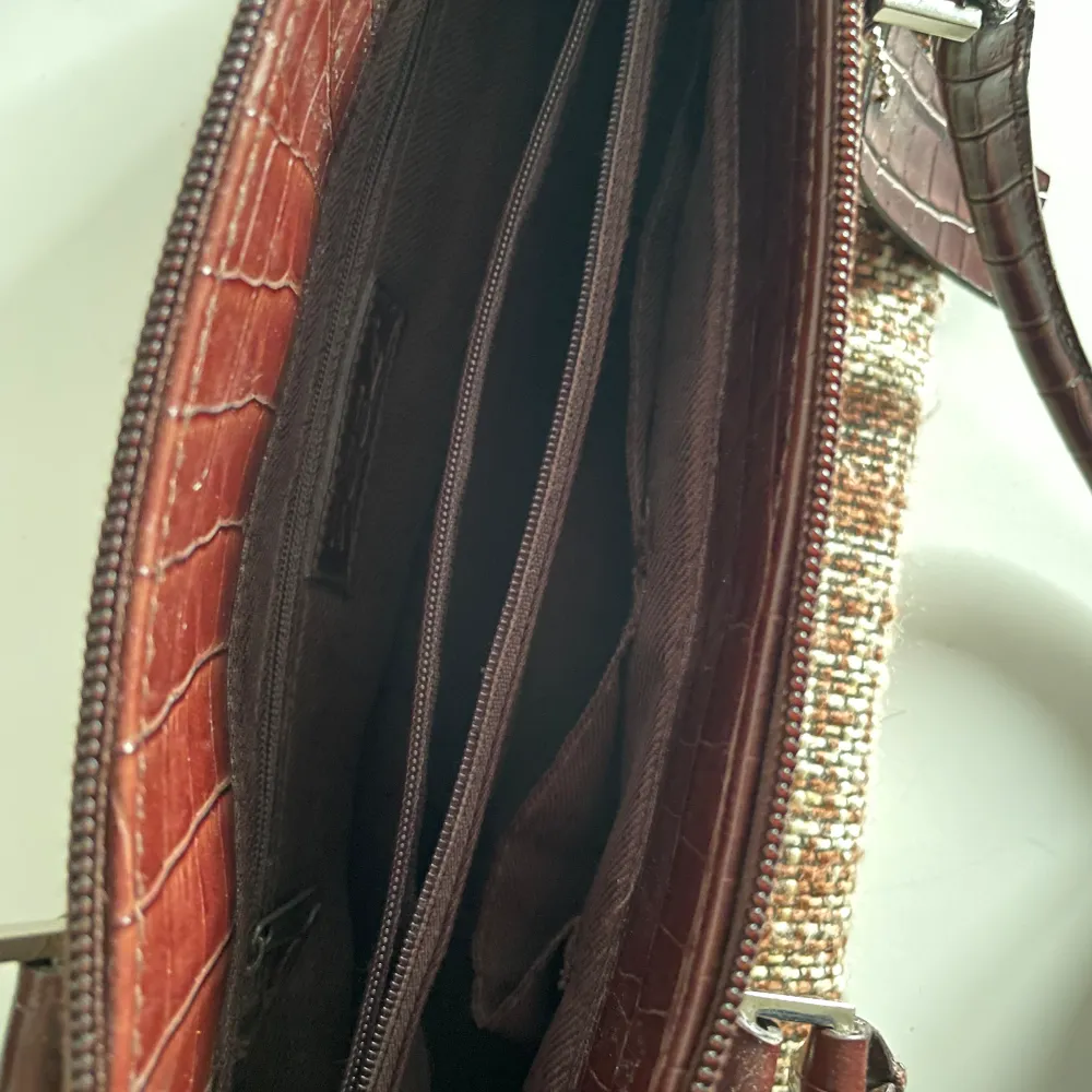 Mindre brun vintage handväska i bra skick med fyra inre fack varav två med dragkedja. Frakt ingår inte☺️. Väskor.