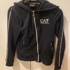 Hej! Jag säljer min EA7 Emporio Armani zip hoodie i storlek 152. Den har otroligt många snygga detaljer och är i jätte fint skick så gott som ny skick. Jag säljer den då den har blivit för lite den användes i typ 2 månader. Hör av er vid minsta lilla