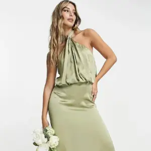 Grön satin klänning som kommer från Asos. Helt oanvänd och jättefint matrial. Är 158 cm, så passar perfekt i längden med klackskor. Bär stolek S annars men sitter jättebra ändå då man kan knyter den själv.  Ordinarie pris 1249 kr 
