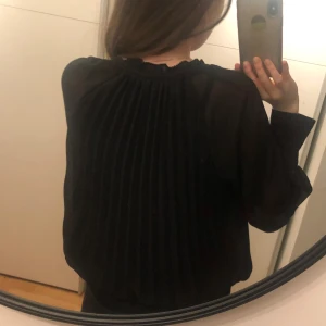 HM blus - Höft lång plisserad blus från HM som jag säljer då den inte kommer till någon användning. Den har knytband på kragen samt en knapp längst ner på bägge ärmarna. Använd ett fåtal gånger, fint skick. Hör av dig vid frågor💞 