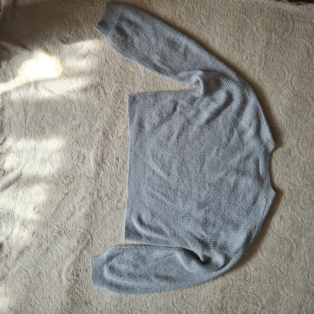 En grå stuckad tröja i storleken 156/164cm. Använd några få gånger. Stickat.