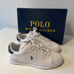 Polo Ralph Lauren skor i marinblå. Aldrig använd, är i perfekt skick och det kommer med vita snören💗 Modell: Heritage Court II Leather Sneaker- Låga sneaker
