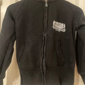 Svart hoodie med cool design - Svart cropehoodie med cool design på baksidan påminner lite om christan audiger eller ed hardy 