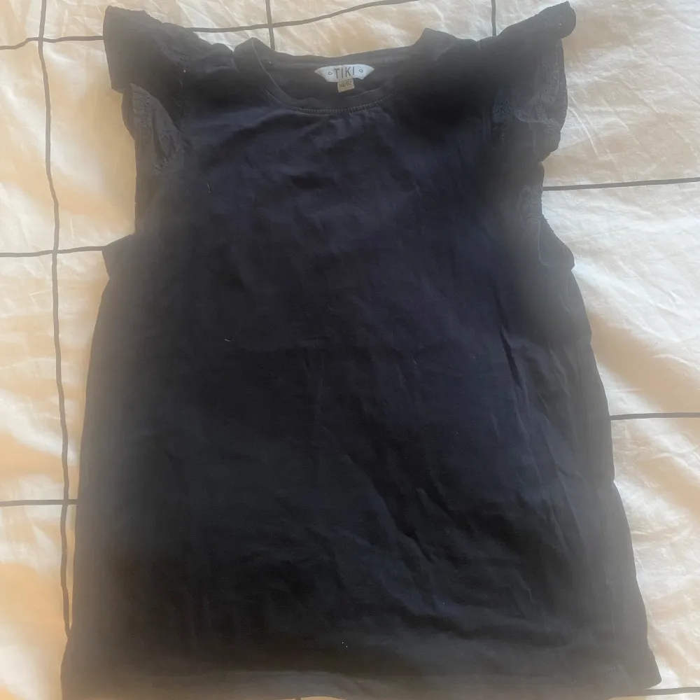 Det är en svart tröja med volang i armen. Den är i storlek 146/152❤️. T-shirts.