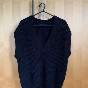 Stickad väst - Svart stickad väst. Liten i storleken.