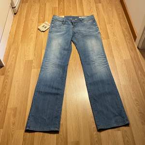 (41) lågmidjade bootcut jeans, helt nya med lappar kvar i ljusblå färg. Midjemått rakt över:38 cm, innerbenslängd: 85cm eller strlk 36 🩵