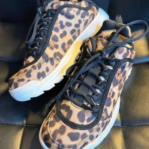 Leopardmönstrade mocka sneakers - Jättesnygga leopardmönstrade mocca sneakers med vit sula & svarta snören Jättebra skick,använda 2-3 ggr Dom har räfflad sula Storlek 36(normal i storleken) Totallängd under skon 26cm Klackhöjd 3cm Jätteskönt & bekväm modell med vadderad häl