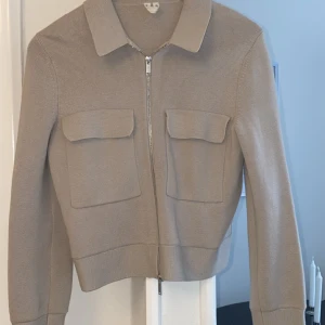 Stickad vårjacka  - Beige jacka från Arket, sparsamt använd. Rak i passform hellre än boxig. 