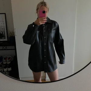 Svart skjorta  - Jättesnygg svart ”läder”-skjorta i en oversize passform. Går absolut att ha som klänning om man är kortare än 168cm (jag är 168). Strl 40 oversize. 🖤