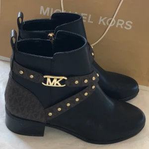Svarta boots Michael Kors stl 39-39,5 - Använda 1 gång mkt fint skick  Svarta med brunt monogram och guld detaljer Stl 39/39,5   