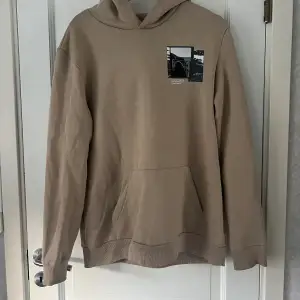 Beige hoodie med tryck från Bershka i storlek M. Lite ljusare beige i verkligen. Använd ett fåtal gånger så kvalitet som ny. Köparen står för frakten!!🥰💕💕