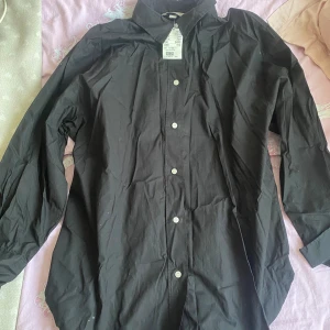 Skjorta - Andrig använd och prislappen kvar. Lite rynklig men försviner om man stryker den.