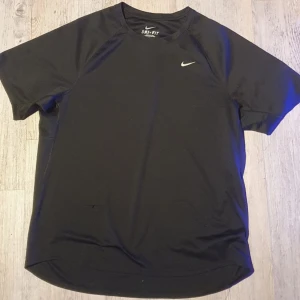 Nike dri-fit svart träning t-shirt - Den har en liten repa på nedersta vänstra delen av framsidan men det är ingenting som går igenom hela tyget. Annars är den i ganska bra skick och materialet är väldigt bra kvalité.