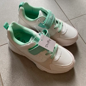 BARN sneakers  - Oanvända skor i storlek 31. Vita som skiftar i färg i solljus 