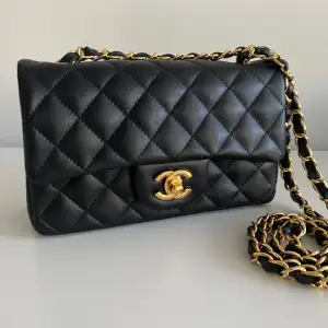 Chanel inspirerad classic flap väska i storleken medium. Helt ny. Det finns en metal chip inuti som i de nyaste Chanel modellen. Caviar läder i svart färg med  guldiga detaljer. Kommer med box, bandet, blomman och dustbagen. Mått 15.5 × 25.5 × 6. Hög