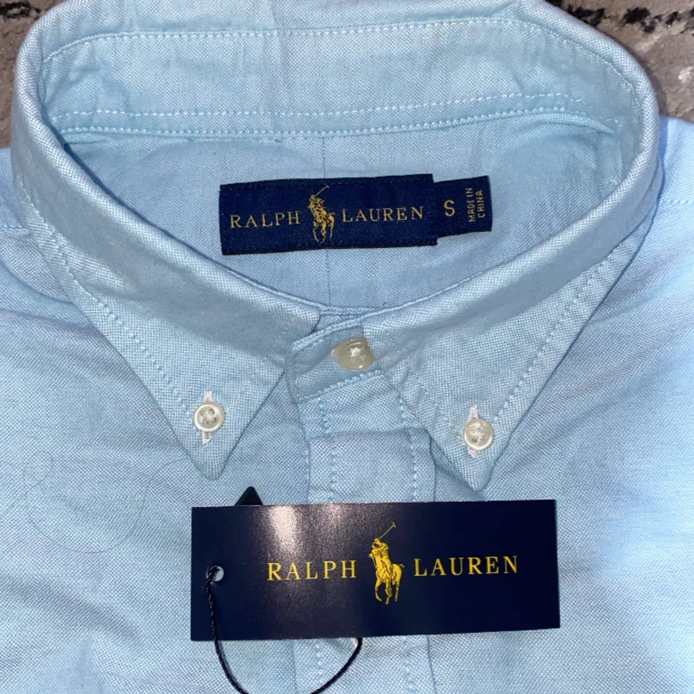 Tja! Säljer min Ralph Lauren skjorta då den är för stor på mig.Helt oanvänd ny pris 1599,riktigt skön och somrig färg, storlek S men passar M.. Skjortor.