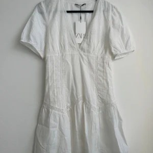 Vit klänning från zara - Vit sommarklänning från zara. Jättefint mönster. Volang. Urringad. Säljer då den var för liten för mig. Perfekt studentklänning🥰