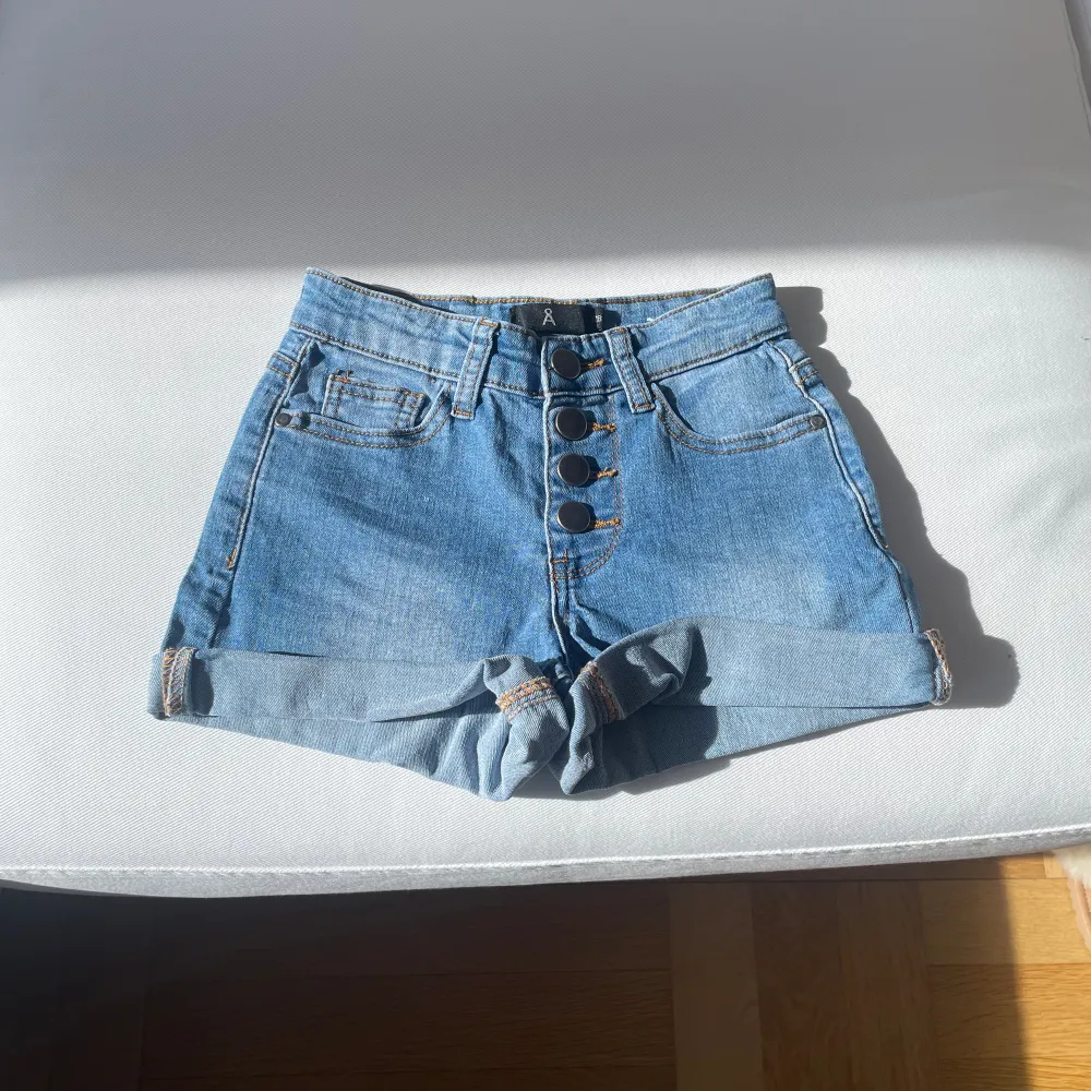 Säljer dessa jättefina och somriga jeans shortsen, midjemått: 58cm, shortsen är höjmidjade med 4 st knappar, bra skick har använts fåtal gånger, säljer på grund av att de inte e min stil . Shorts.