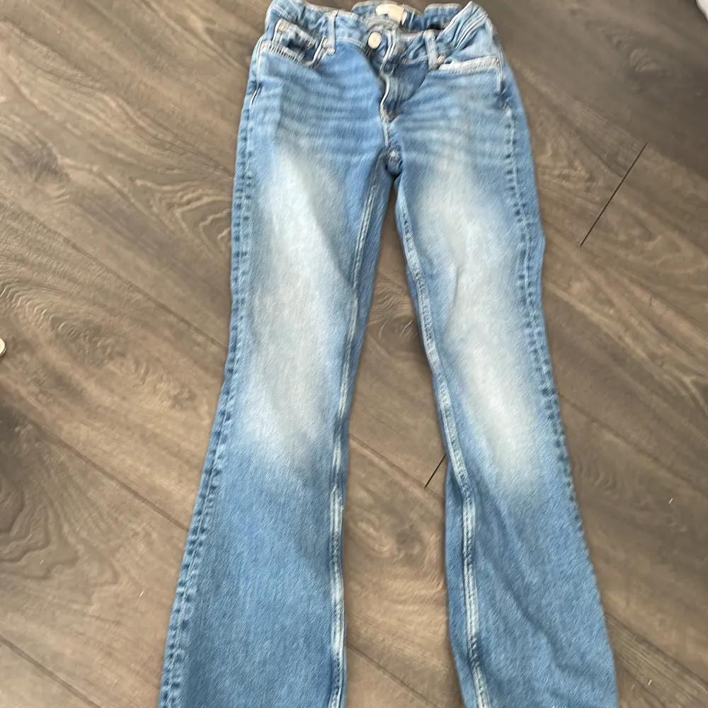 Säljer blå lågmidjade utsvängda jeans från Gina Young. Använda men bra skick förutom utslitna längst ner. (Se bild). Stl 158. Säljer pga att de är för korta för mig. Orginalpris ca 350kr. Jeans & Byxor.