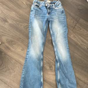 Säljer blå lågmidjade utsvängda jeans från Gina Young. Använda men bra skick förutom utslitna längst ner. (Se bild). Stl 158. Säljer pga att de är för korta för mig. Orginalpris ca 350kr