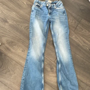 Bootcut jeans - Säljer blå lågmidjade utsvängda jeans från Gina Young. Använda men bra skick förutom utslitna längst ner. (Se bild). Stl 158. Säljer pga att de är för korta för mig. Orginalpris ca 350kr