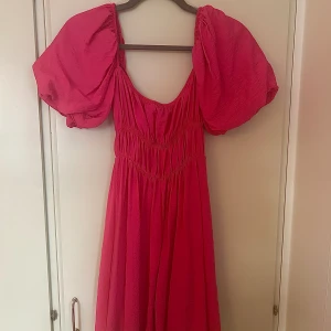Rosa sommarklänning med ballongärmar  - En rosa sommarklänning med stora ballongärmar. Är lagom i storleken och har används endast en gång så är i väldigt bra skick. Klänningen går lite över knäna. 