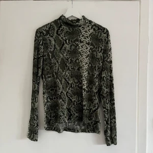 Tunn ormmönstrad polotröja - Ormmönstrad tunn tröja med hög krage, använd några gånger. 