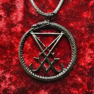 En magisk gåva till dig själv eller någon du tycker om.  Svart halsband med amulett med Lucifers sigill, i cirkel som är en slingrande orm, bandet är av konstläder.  Halsbandet är 50 cm totalt med 5 cm att justera med. Amuletten cirka 5x5 cm. 